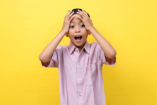 istock Happy surprised asian boy standing while screaming with unbelievable expression. Isolated on yellow 2213286004