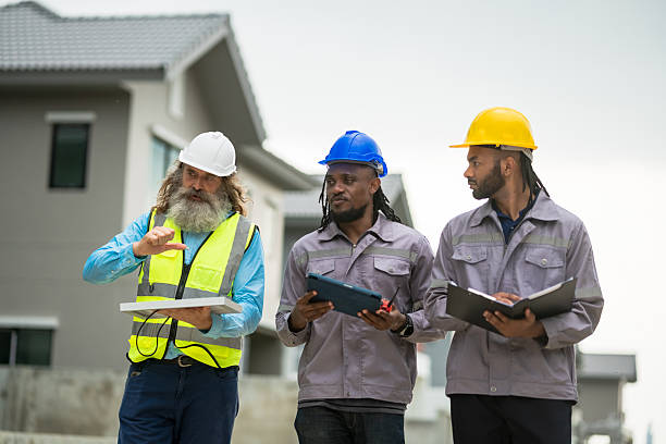 istock Three men in construction gear are walking down a street, each holding a clipboard. Scene is serious and focused, as the men are likely discussing plans or progress on a project 2213287907