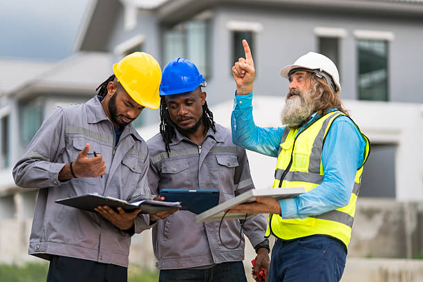 istock Three men in construction gear are looking at a tablet. One of them is pointing at something. Scene is serious and focused 2213287916