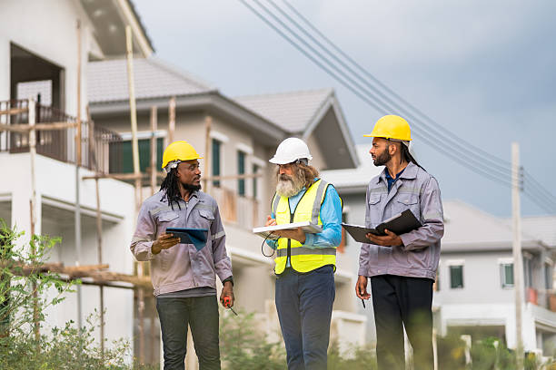 istock Three construction workers are walking down a street, each holding a clipboard. Scene is serious and focused, as the workers are likely discussing plans or reviewing blueprints 2213287924