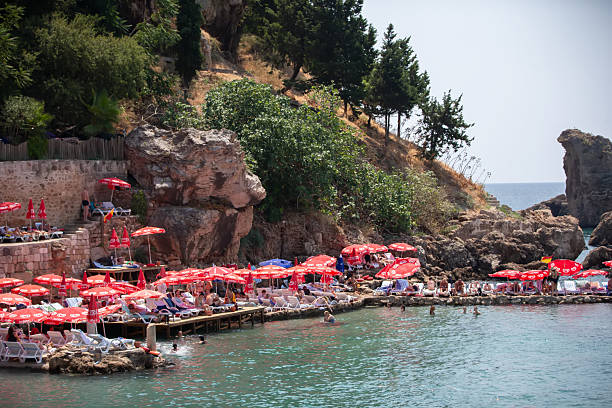 August 04, 2024 Turkiye Antalya Kaleici public beach. A group of tourists on a Turkish beach.