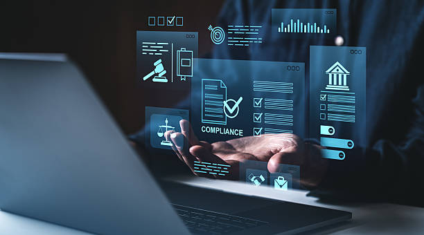 istock Digital compliance and data regulation concept with holographic interface above hands near laptop on dark blue creative background.. 2213300574