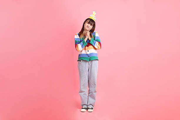 HAPPY BIRTHDAY, Asian woman with colorful rainbow winter clothes , casual look, birthday hat with gesture of impressive isolated on pink background. Gen Z,