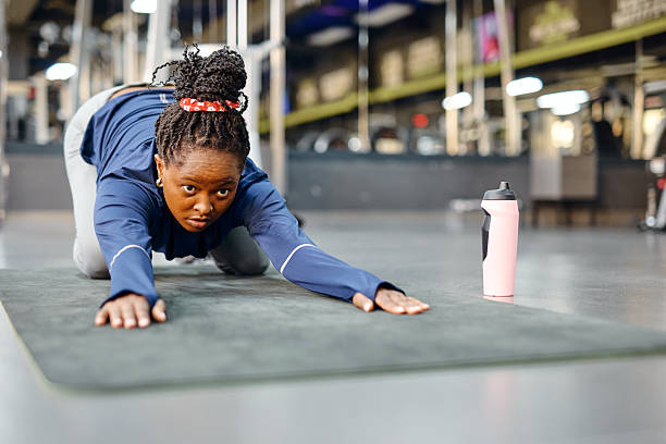 istock Young woman stretching on a mat in a gym 2213307189
