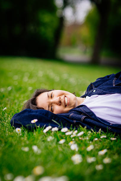 istock Beautiful woman relaxing on a grass 2213307248