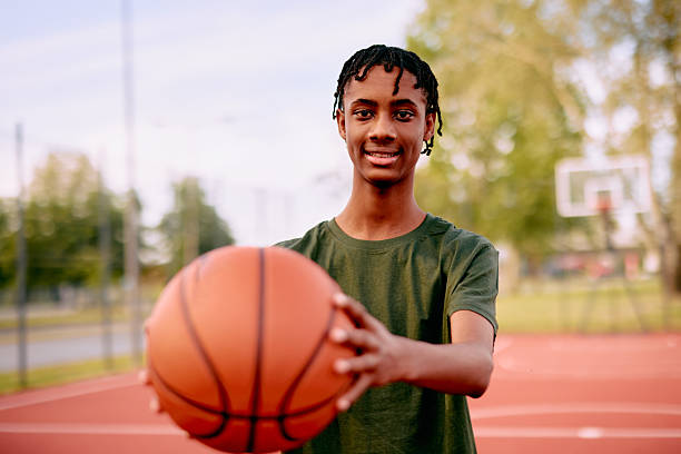 istock Young basketball player holding ball and smiling 2213309666