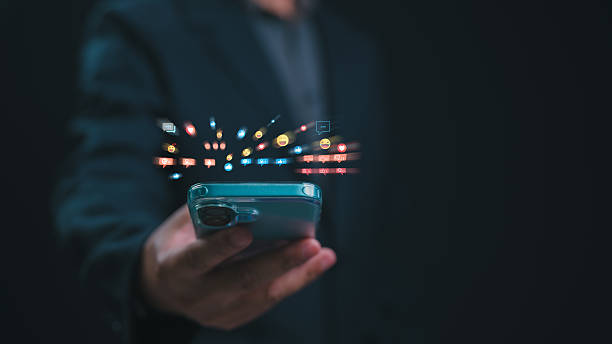 istock Digital Engagement Explosion Hand Holding Smartphone Shows Social Media Influence, Glowing Icons Of Likes, Comments Hearts Bursting From Screen, Driving Business Activity On Platform 2213310773