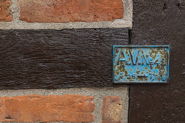 Close-up of a rustic brick wall with dark timber beams, historic architecture in Ystad, Sweden. Detail of facade.