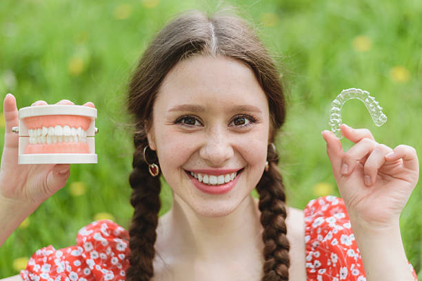 istock Dental care. Smiling woman holding aligners. Plastic retainers for teeth alignment. 2213313939
