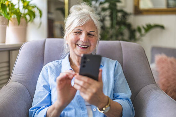 istock Senior woman using mobile phone at home 2213315394
