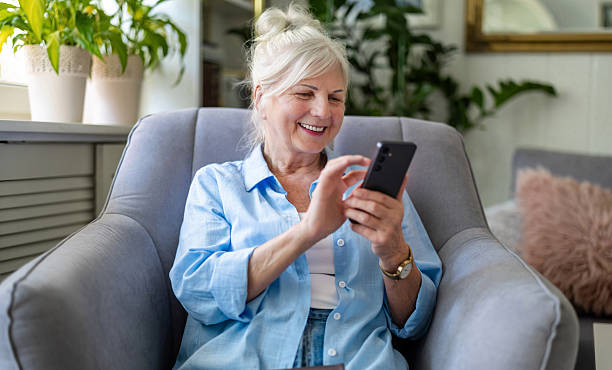istock Senior woman using mobile phone at home 2213315404