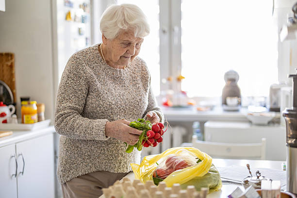 istock Senior woman in the kitchen, checking her fresh vegetable delivery 2213315518
