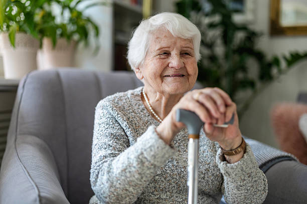 Elderly woman resting her hands on a cane