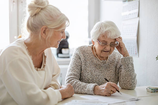 istock Woman helping her elderly mother preparing financial documents 2213315696