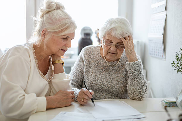 istock Woman helping her elderly mother preparing financial documents 2213315732