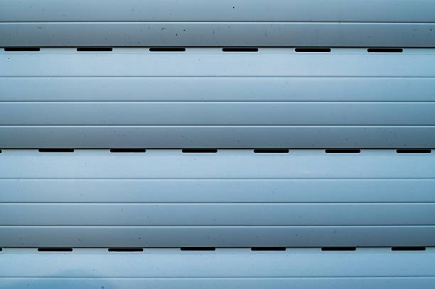 Close-up of a blue garage door showing horizontal slats and ventilation slots, creating a textured and secure background