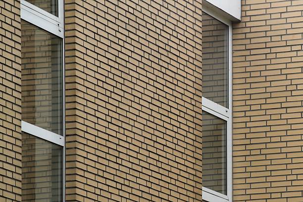Tan brick wall and windows create a modern and stylish exterior for a building