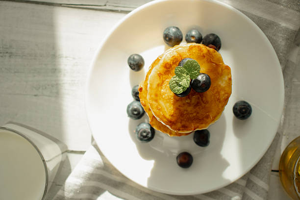 Pancakes with berries and honey. on the table.