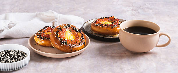Baked bagel with tomato and quail egg on a plate on the table web banner