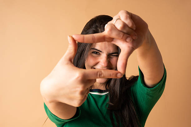 istock Young woman making a frame with her fingers and smiling 2213320029