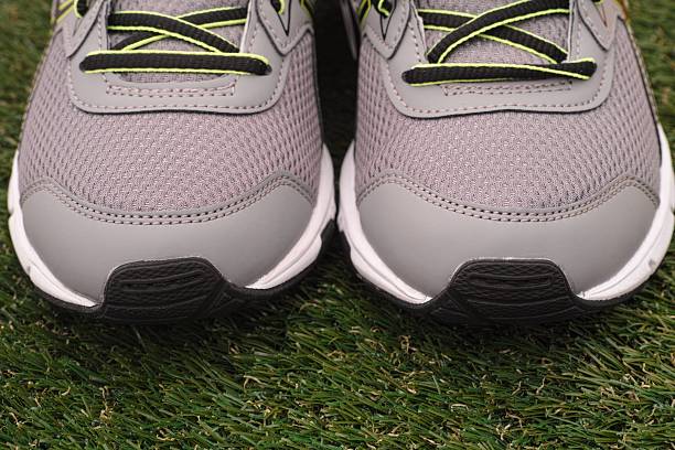 istock Gray running shoes on a grass background. Close-up 2213321331