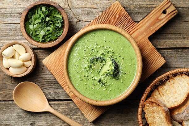 istock Delicious broccoli cream soup served on wooden table, flat lay 2213323588