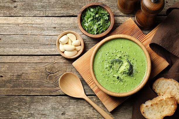 istock Delicious broccoli cream soup served on wooden table, flat lay. Space for text 2213323603