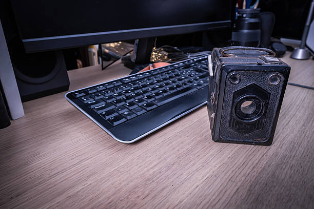 istock Vintage camera and modern keyboard sitting on a desk comparing old and new technologies 2213323670