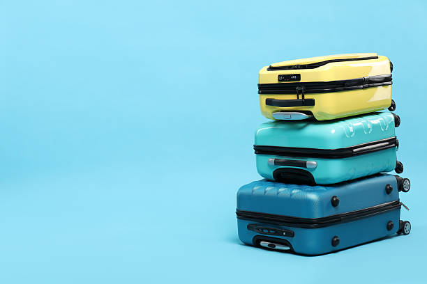 istock Stack of colorful suitcases on light blue background. Space for text 2213323799