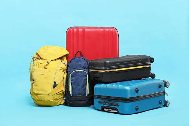 istock Colorful suitcases and backpacks on light blue background 2213323802