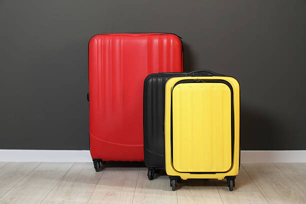 istock Colorful suitcases on floor near black wall 2213323809