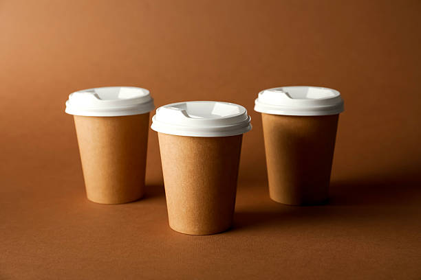 istock Paper cups with lids on brown background. Mockup for design 2213324640