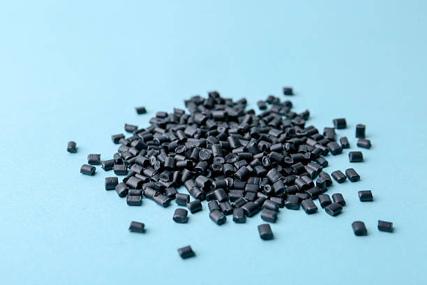 istock Pile of black plastic granules on light blue background, closeup 2213324881