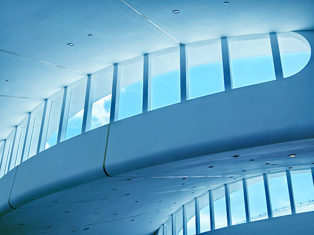 The ceiling of a vast building that features numerous windows