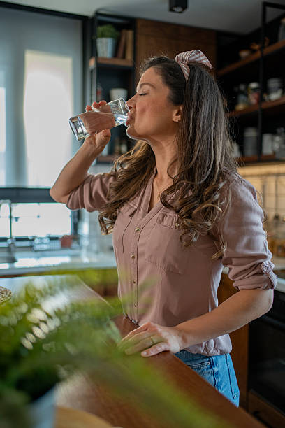 istock Woman drinking fresh water in the kitchen 2213326737