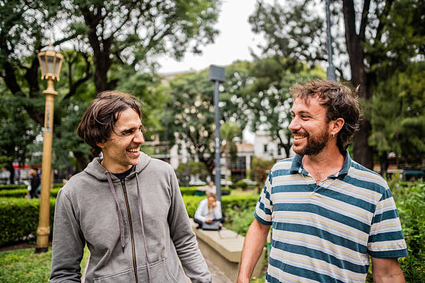 istock Friends talking and walking in a public park 2213328240