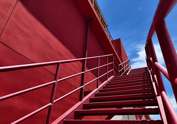 istock A set of stairs ascending a large red wall 2213328463