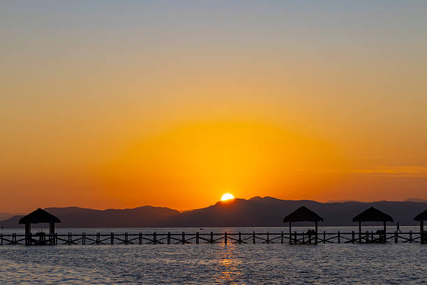 jetty silhouette at sunrise on seraya island in indonesia.