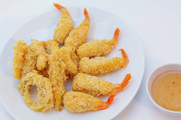 Shrimp Tempura, fried prawns, batter-fried prawns, Crispy golden tempura shrimp and vegetables on white plate with dipping sauce, bright clean background, ideal for Asian cuisine and seafood concept