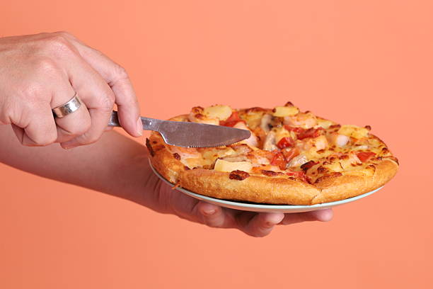 istock Hand holding Hawaiian pizza 2213338709