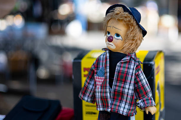 A sad looking clown puppet offered on a flea market - selective focus on front