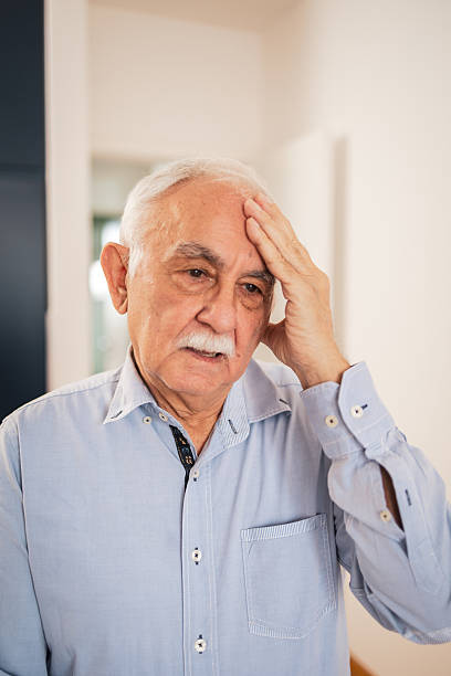 istock Concerned senior man in a thoughtful pose with a hand on his head. He is having a headache 2213343447