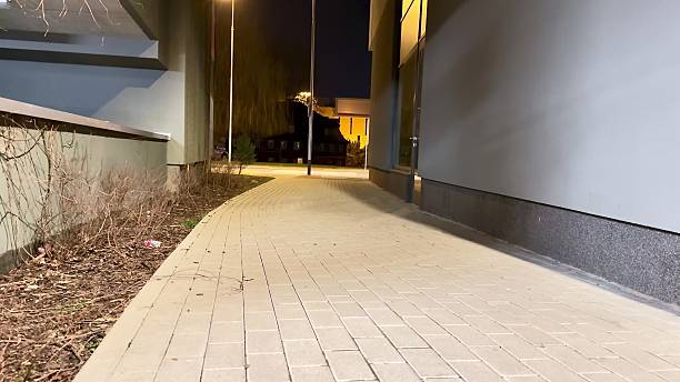 A serene nighttime pathway in a bustling urban setting, offering a peaceful ambiance
