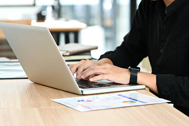 istock A man is typing on a laptop in front of a stack of papers. 2213349933