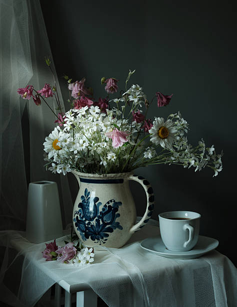 istock Delicate White Flowers Arranged in a Vintage Pitcher Sitting on a Charming Rustic Table 2213351729