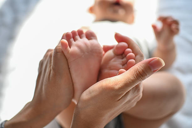 istock Hand with newborn baby's foot 2213353225