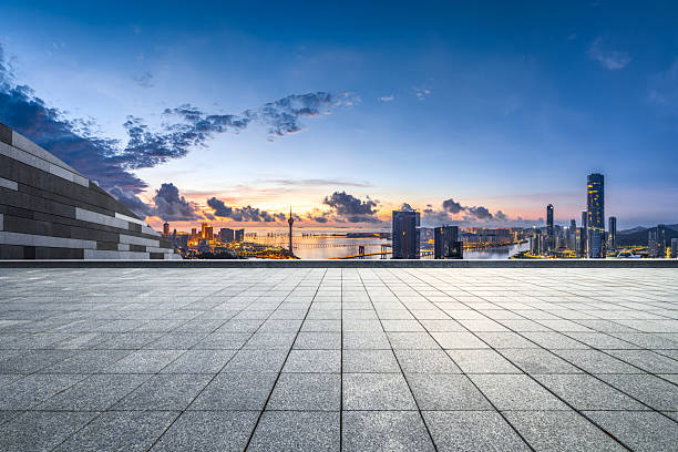 istock Empty stone tile floor platform overlooking the modern city skyline and waterfront buildings at dawn in Macau. 2213353289