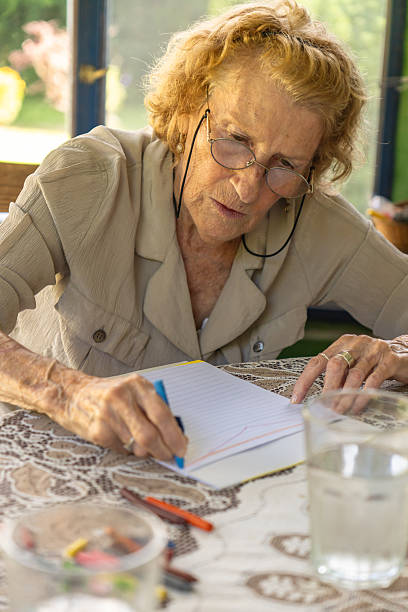 istock Senior woman drawing with crayons at home 2213353974