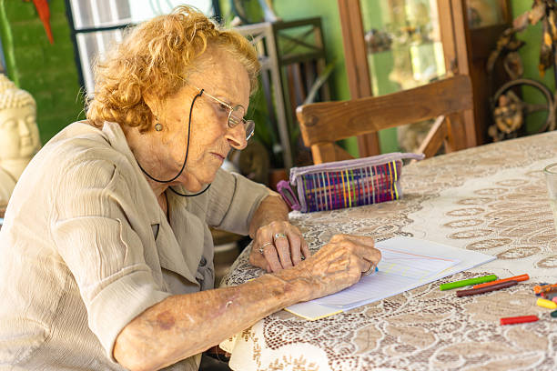 istock Senior woman drawing with crayons at home: expressing creativity in old age 2213354000