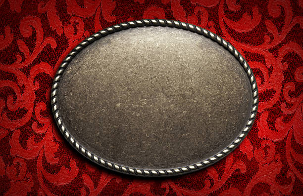A western styled buckle on a red filigree patterned fabric background.